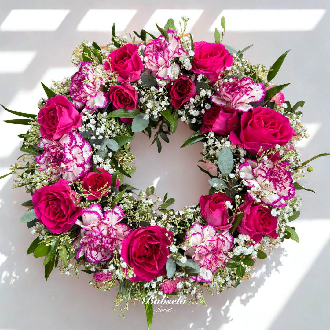 Floral wreath with pink and red flowers on a white background