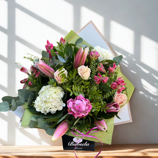 Bouquet of flowers with a pink ribbon on a light background